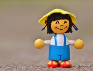 girl in blue dungaree wood toy on ground thumbnail