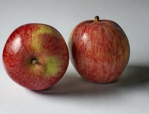 two red apples on white surface thumbnail