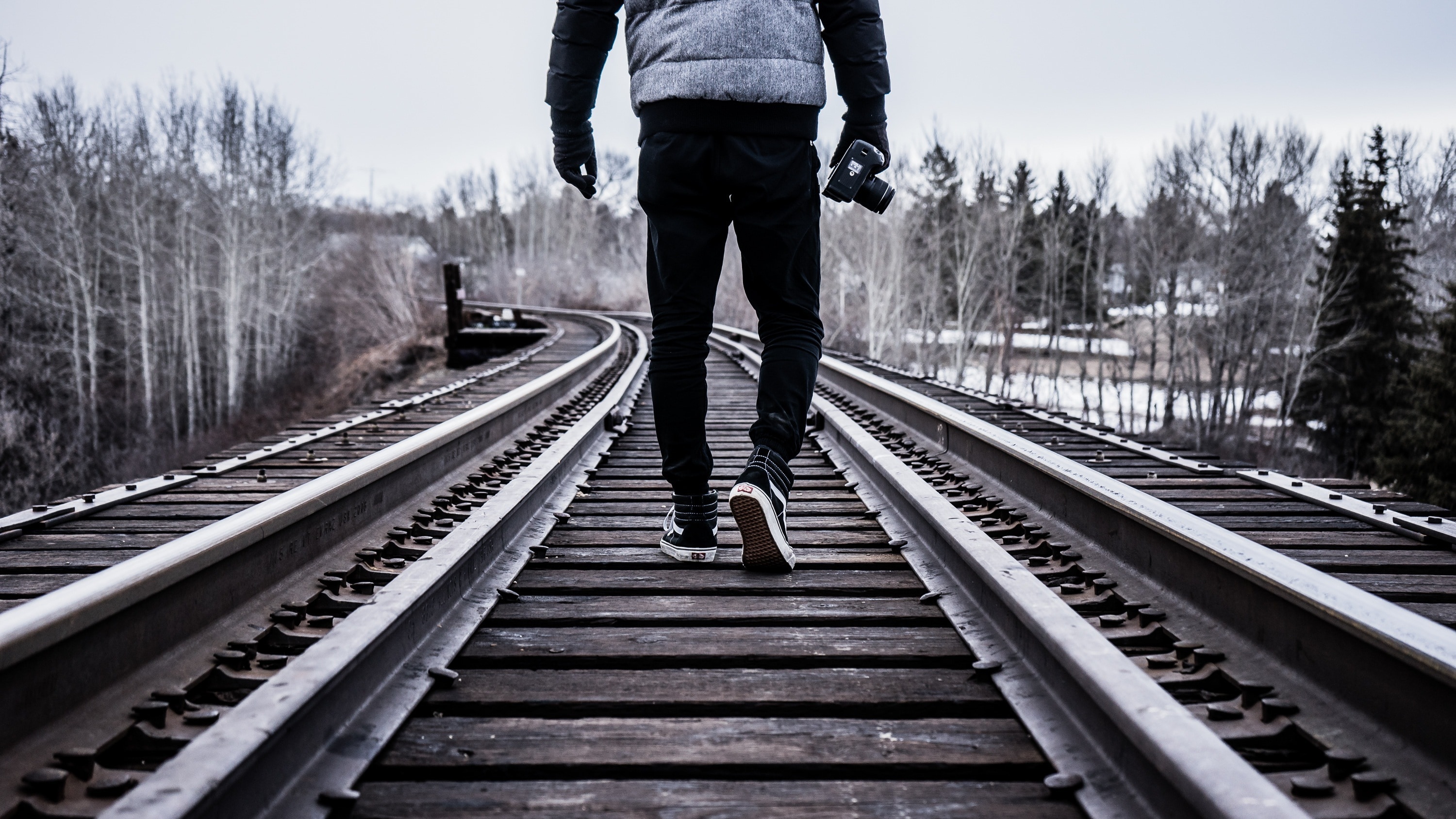 men's black pants and brown wooden train railway