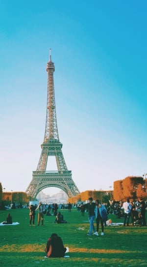 group of people doing their own things in a park in front of Eiffel Tower in Paris France thumbnail