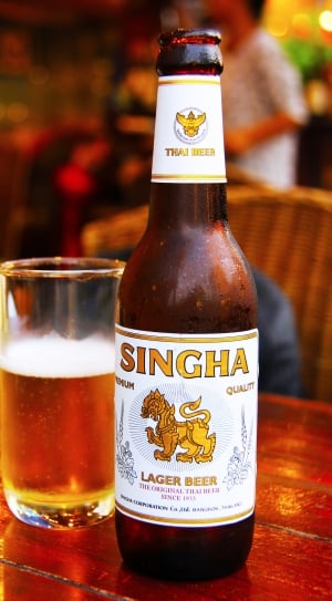 Singha Lager Beer beside of clear drinking glass thumbnail