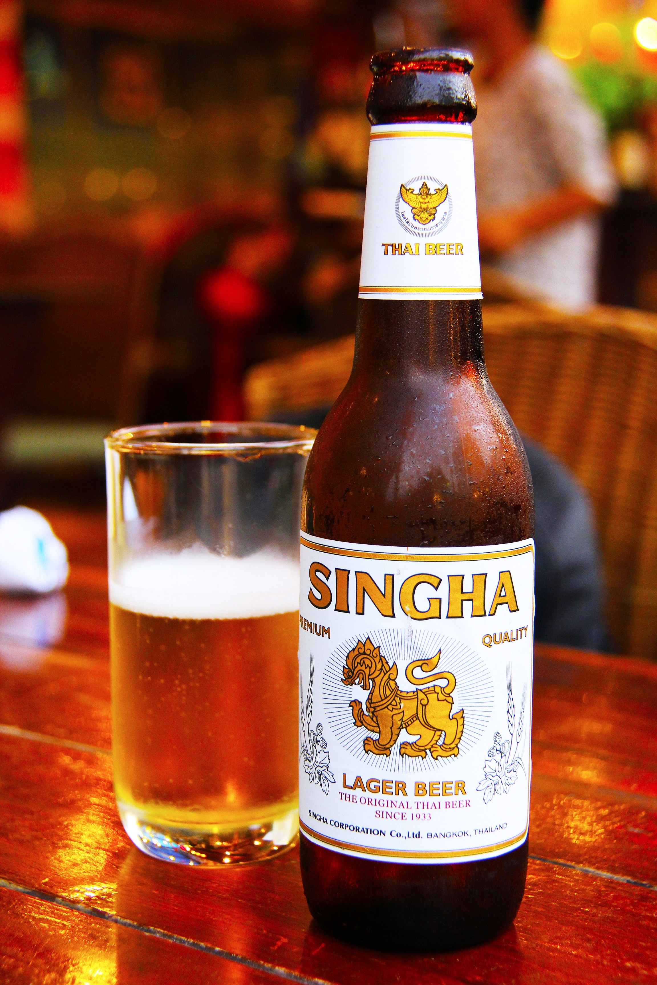 Singha Lager Beer beside of clear drinking glass
