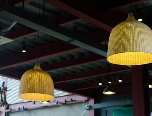 two yellow lighted pendant chandeliers on red and green ceiling thumbnail
