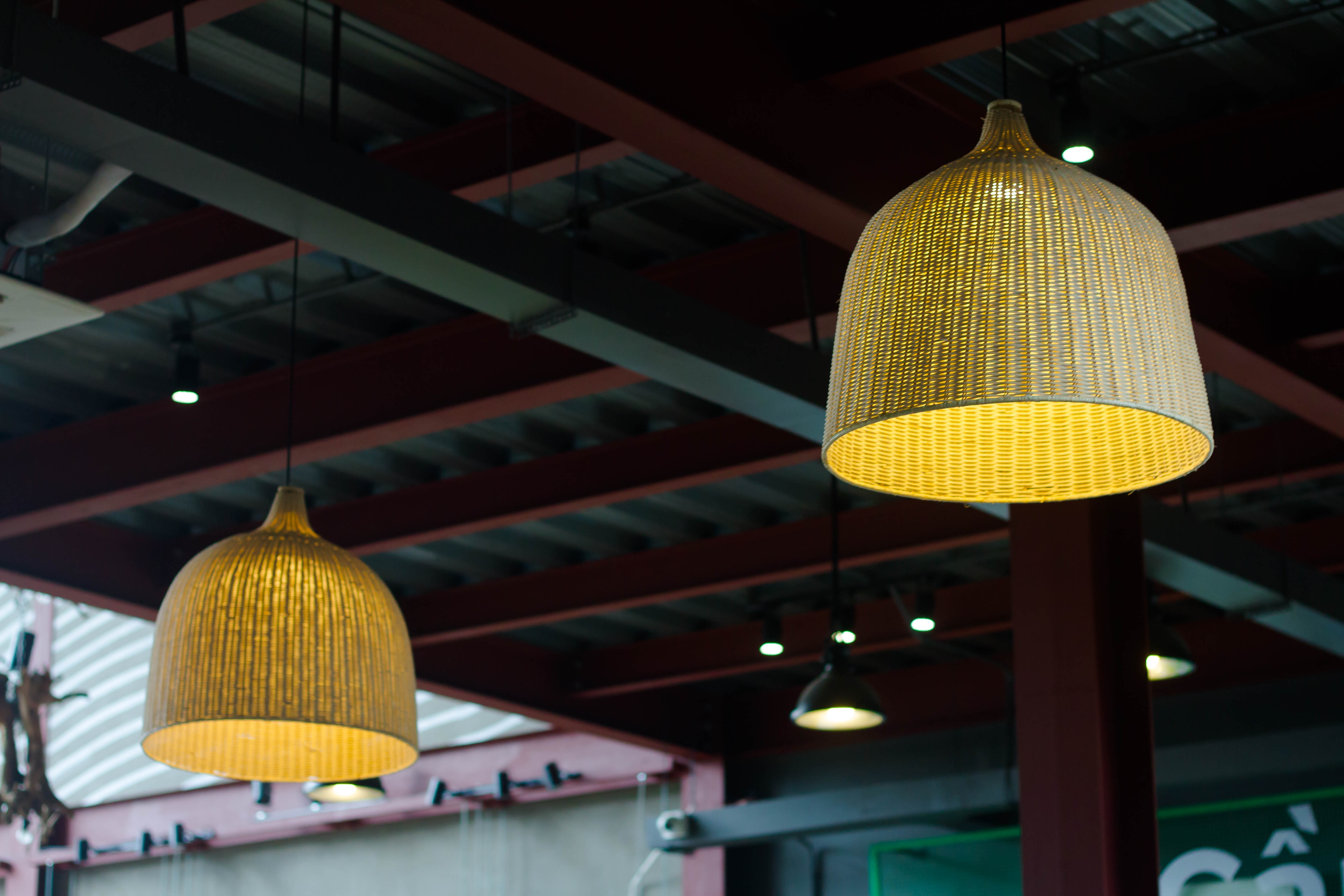 two yellow lighted pendant chandeliers on red and green ceiling