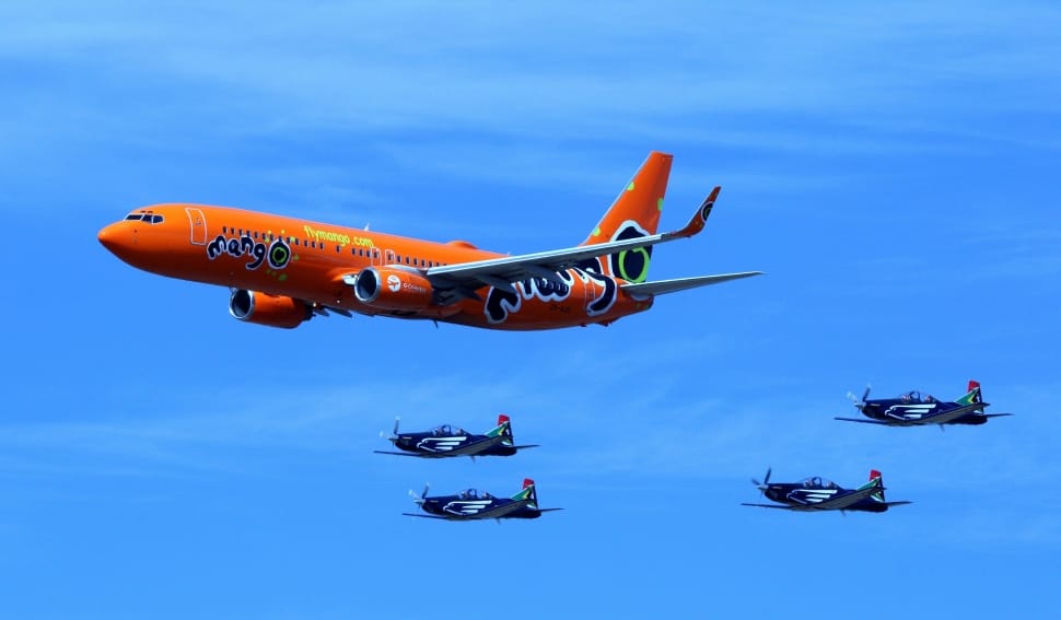 orange commercial plane and 4 black jet planes preview
