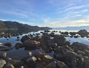gray rocks on calm body of water during daytime thumbnail
