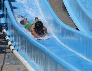 person at blue plastic slide during daytime thumbnail