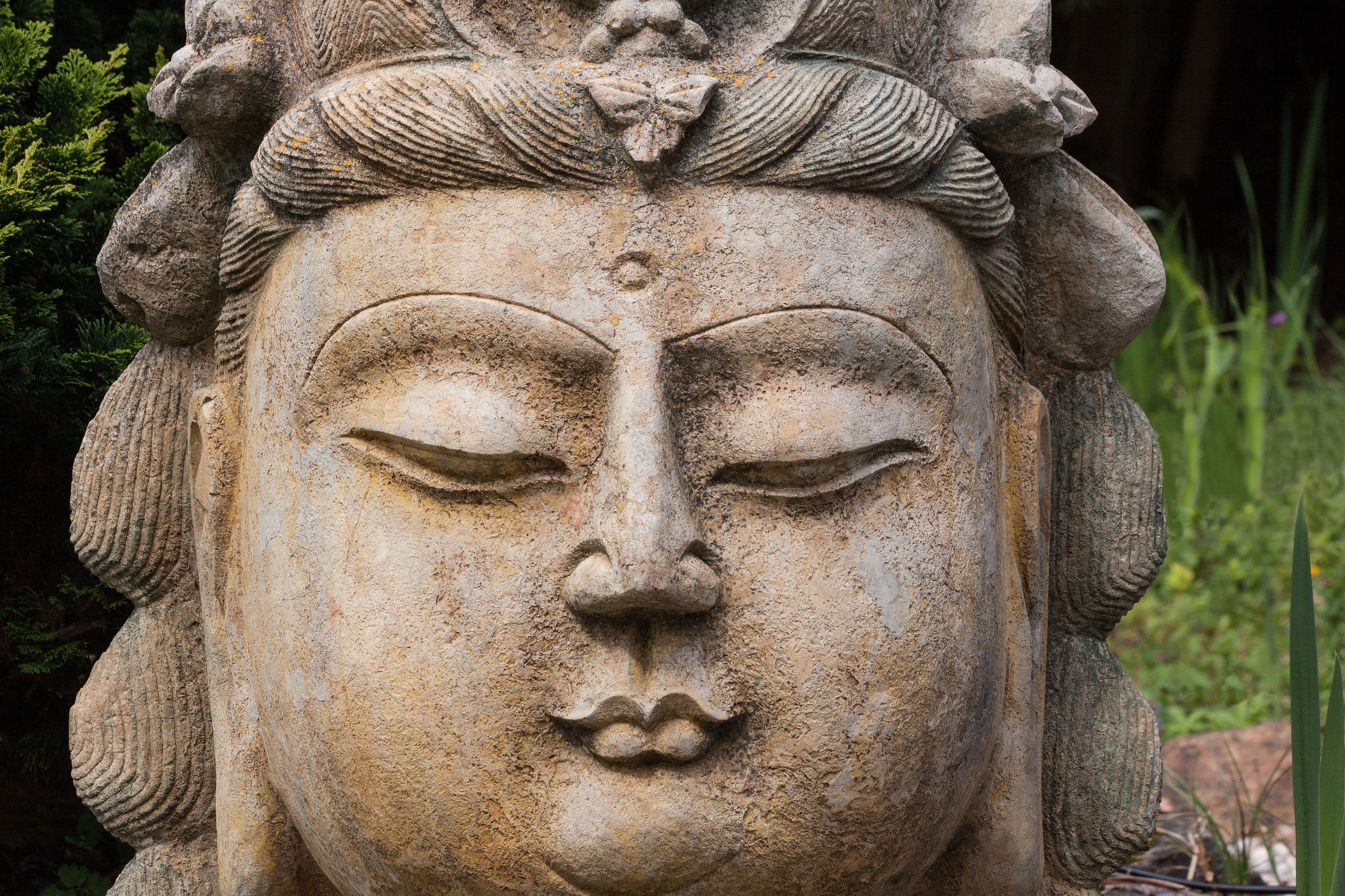 brown and grey ceramic buddha head sculpture