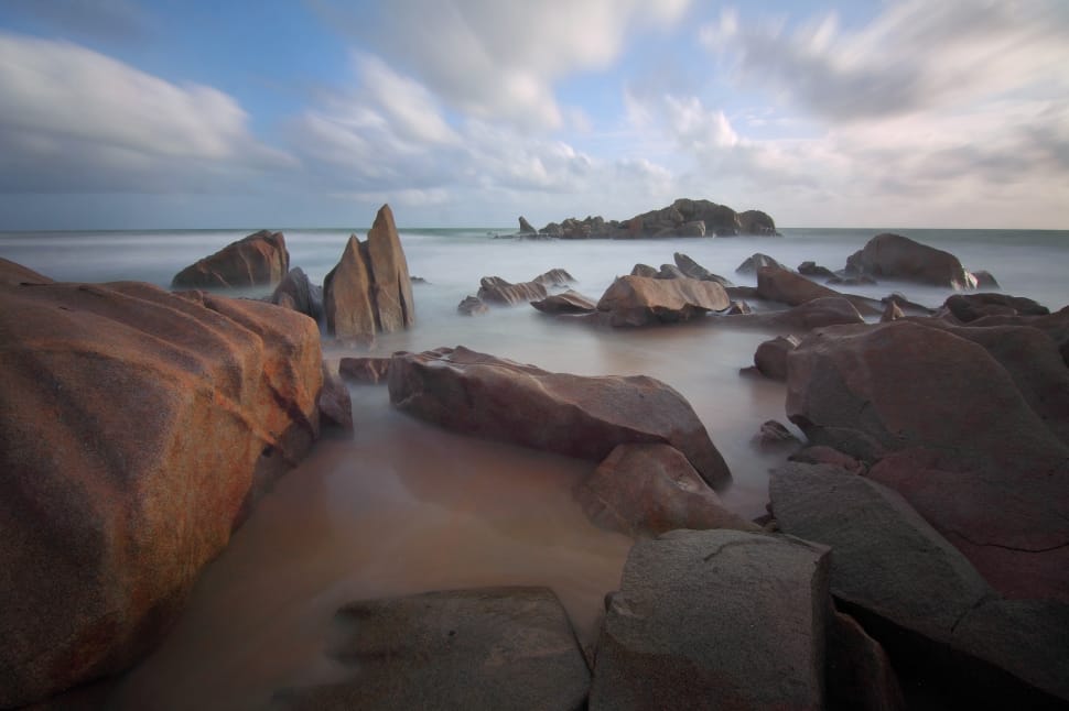 brown rocks on sea water under white cloudy sky preview