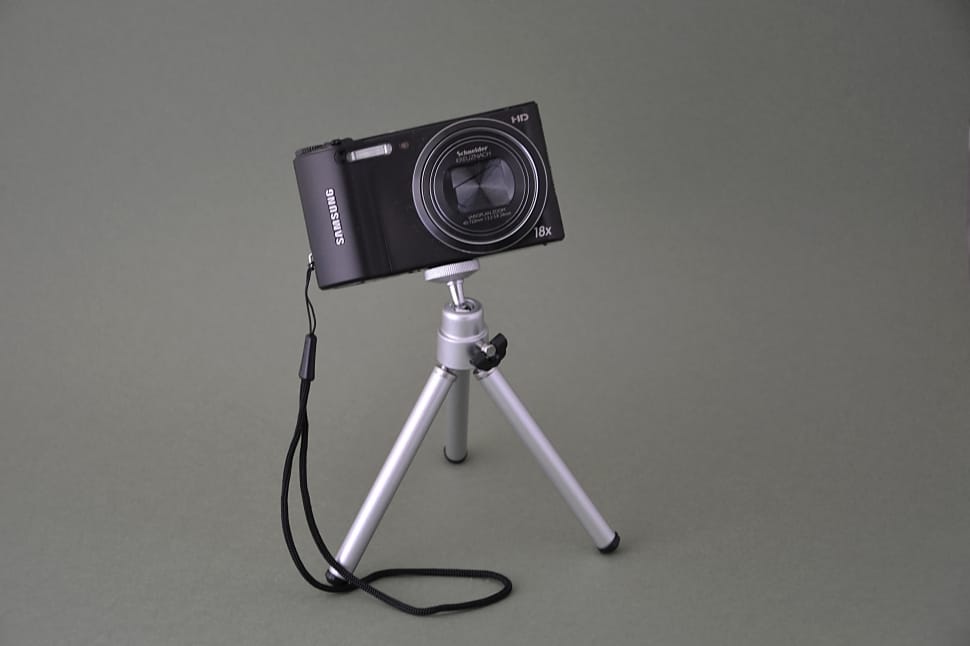 silver tripod and black point and shoot camera preview