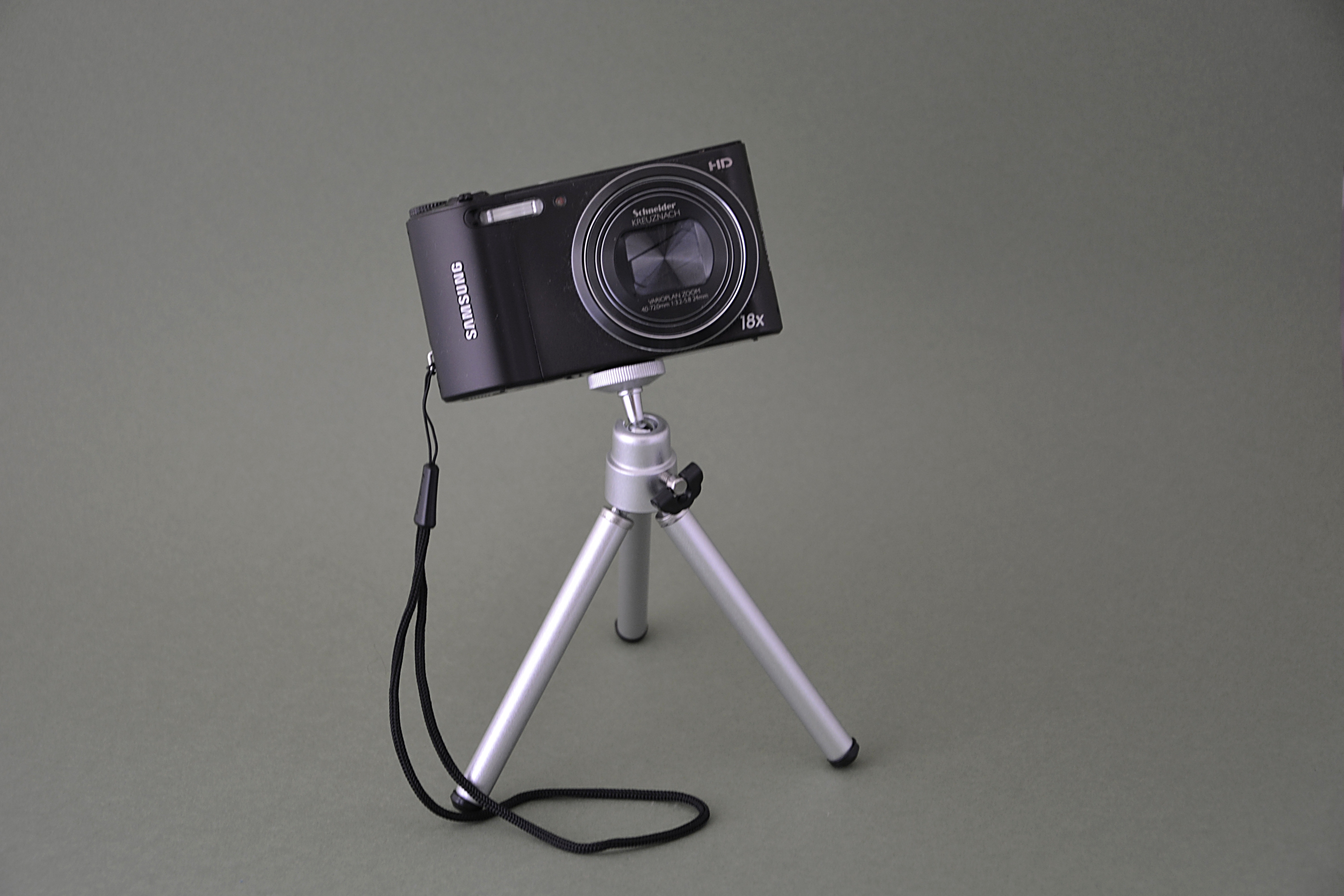 silver tripod and black point and shoot camera