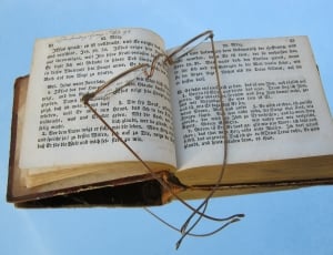 close-up photo of silver frame eyeglasses place on open Bible thumbnail