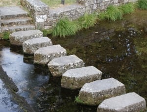 gray slab stepping stones on a body of water during day time thumbnail
