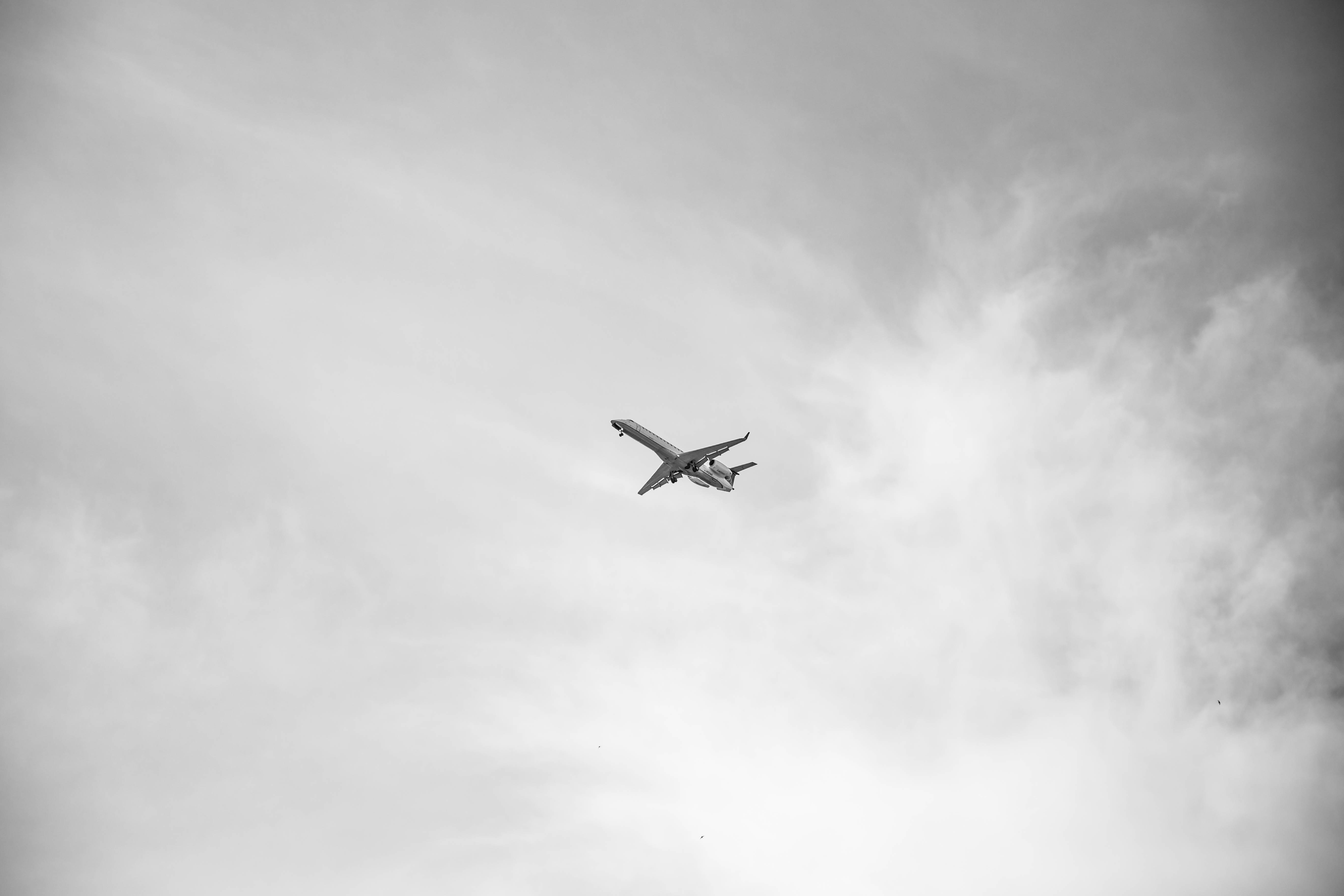 white airplane flying over blue sky