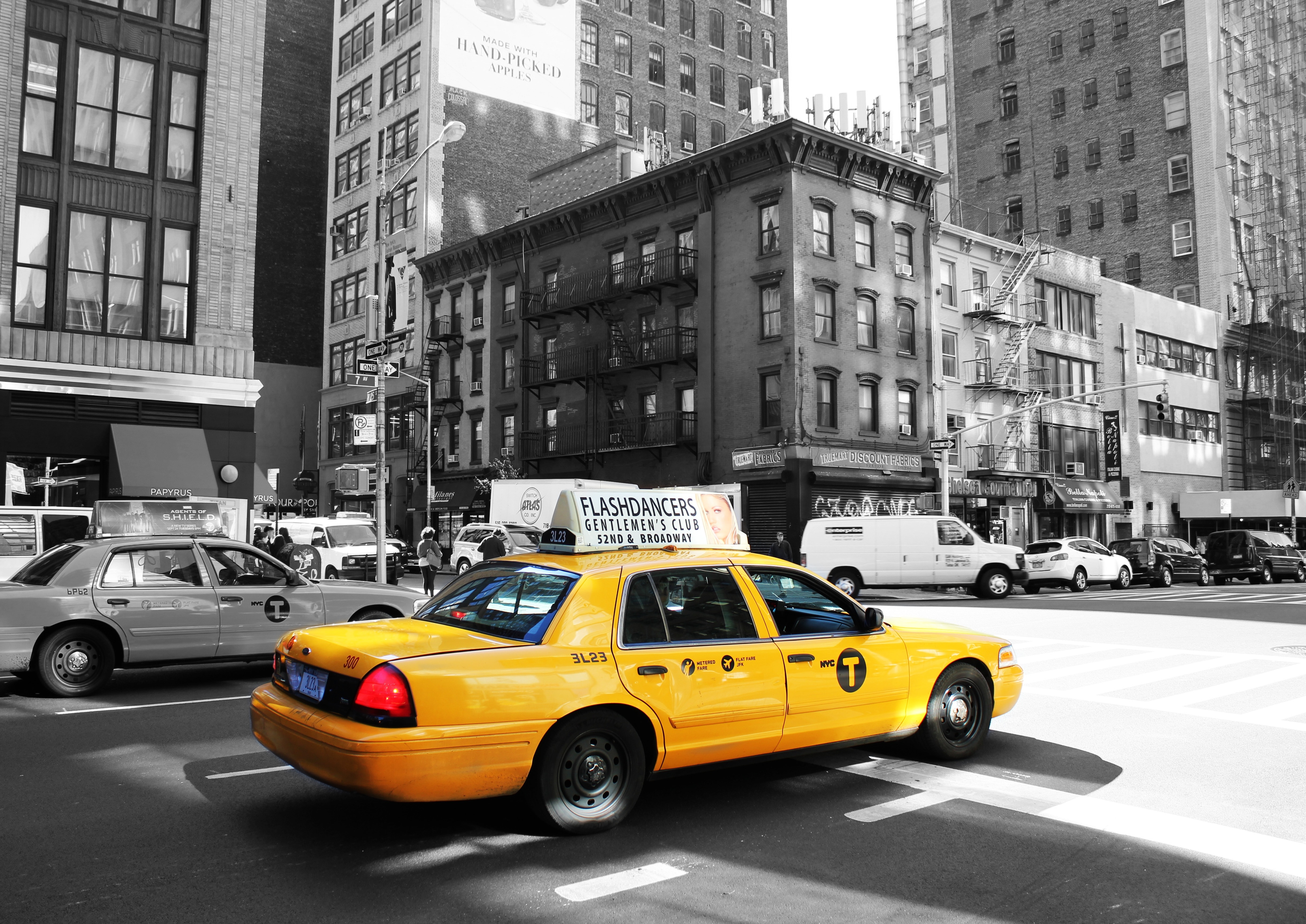 yellow sedan beside gray sedan surrounded by buildings