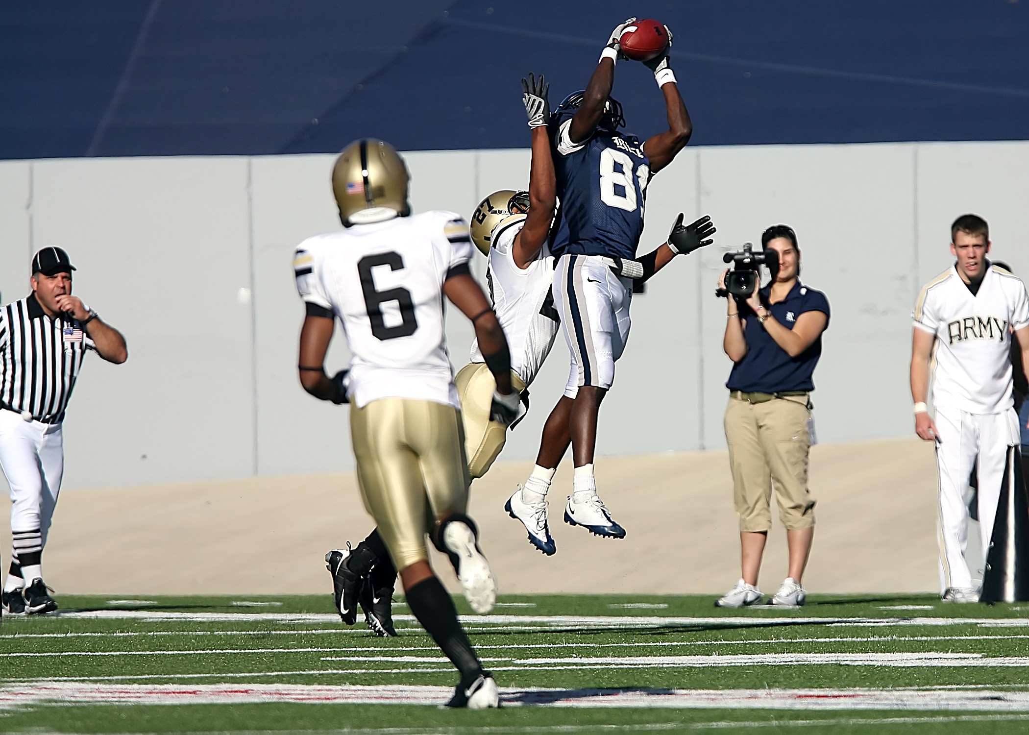 american football player catching ball in middle of the air