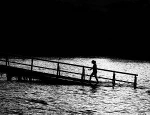 gray scale photography of woman on dock thumbnail
