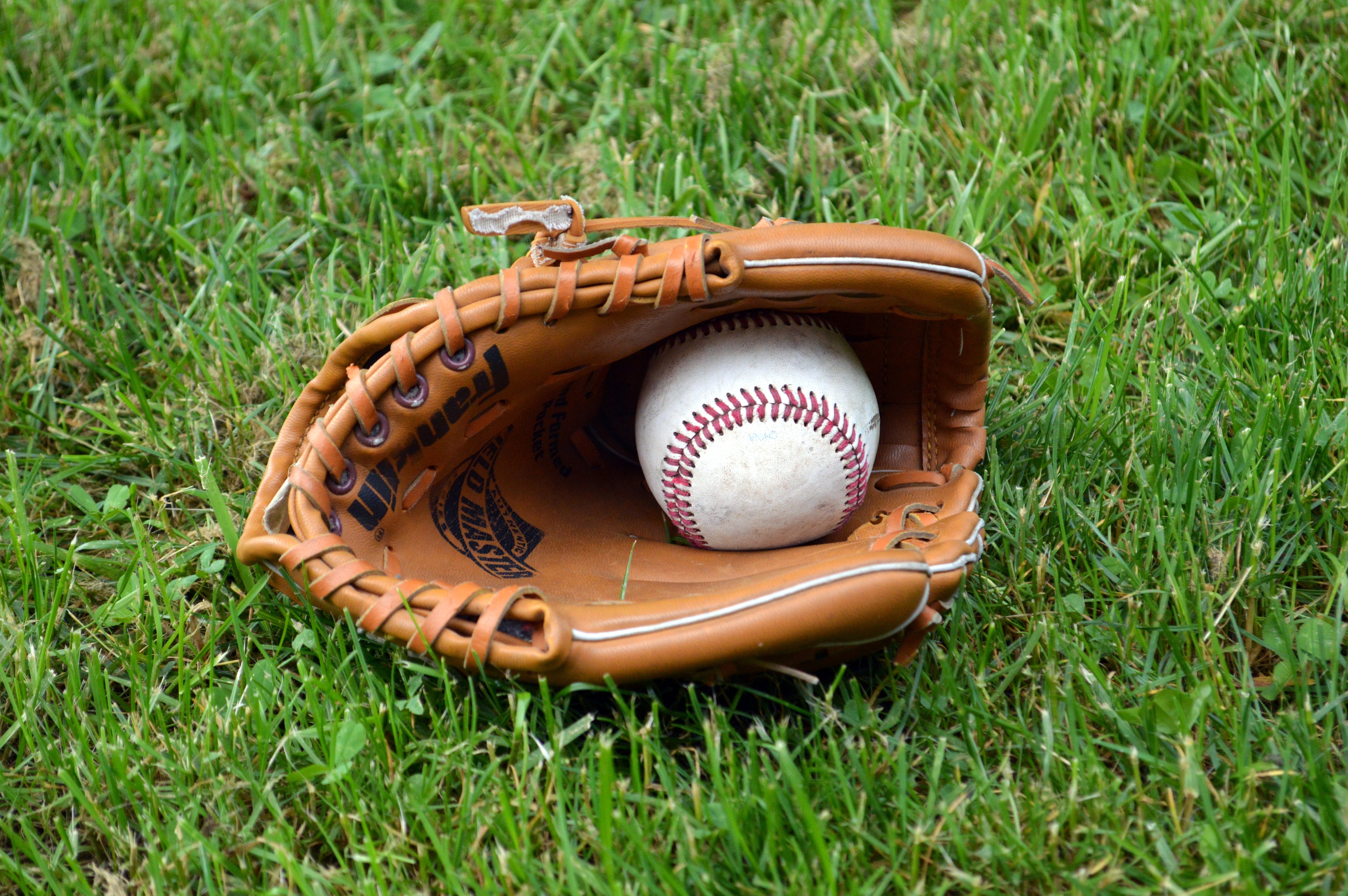 brown baseball mitt with baseball