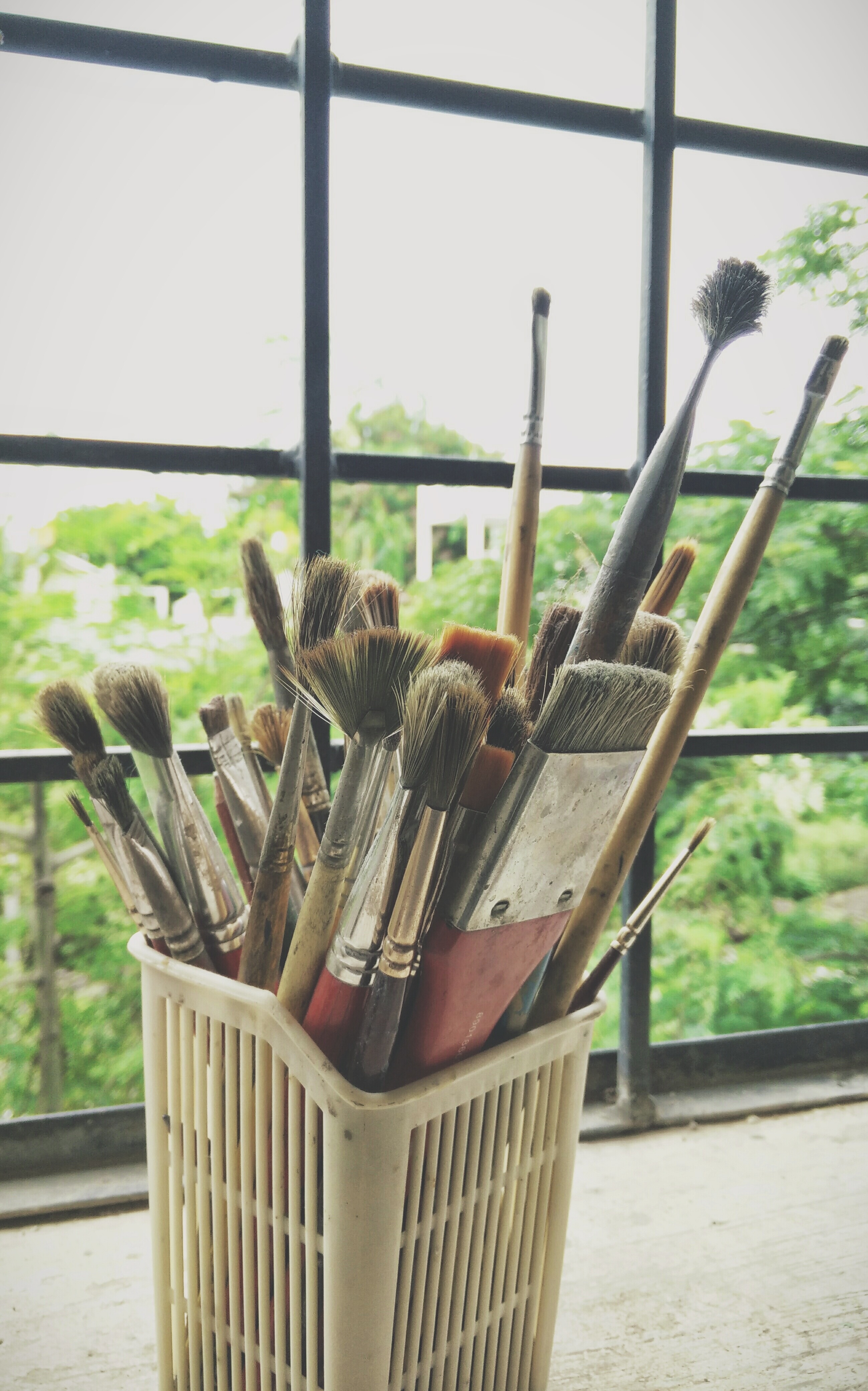 assorted paint brushes in white plastic holder