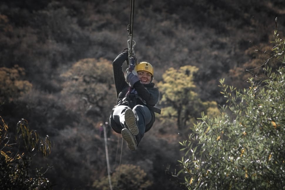 person ride on zip line during day time preview