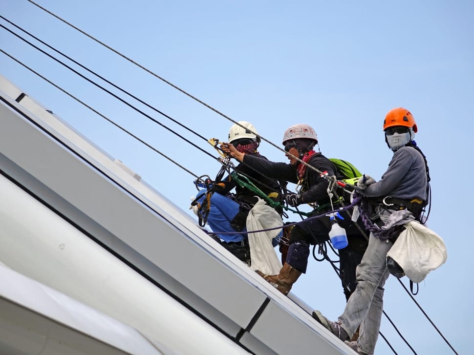three men in roof climbing cables preview
