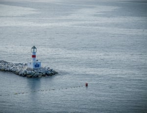white lighthouse and body of water thumbnail