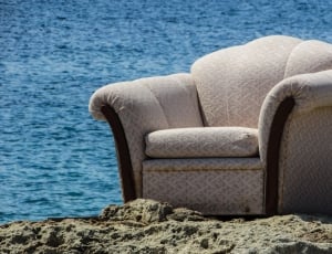 gray sofa chair at the sand dunes near body of water thumbnail