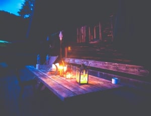 2 lanterns and brown wooden table thumbnail