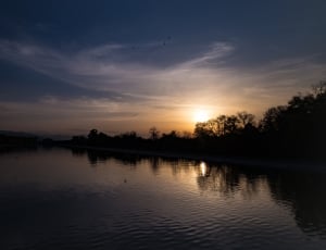 sunset over body of water photo thumbnail
