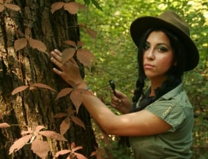 woman standing near tree trunk during daytime thumbnail