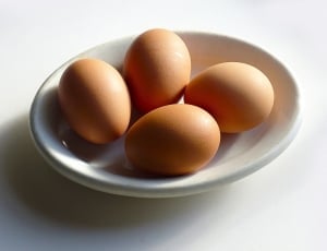4 brown chicken eggs on white ceramic saucer thumbnail