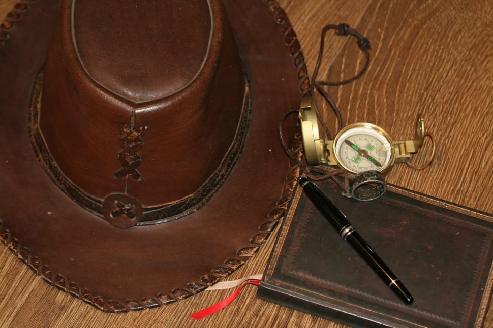 brown leather cowboy hat and gold round compass and black flick pen preview