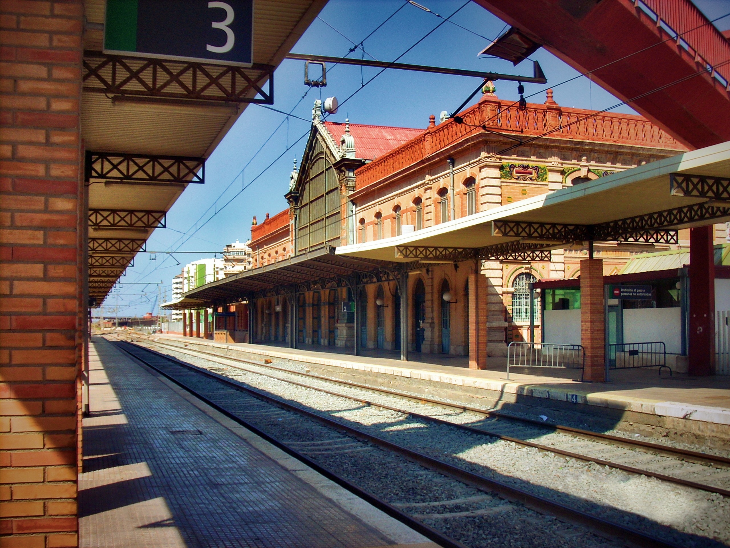 white and brown train station in front of railway during daytime