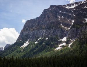 gray rocky mountain with snow caps under white clouds at daytime thumbnail