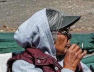 women's grey hoodie and black sun visor hat thumbnail