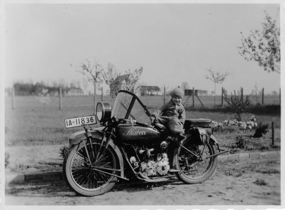 grey scale photo of child sitting on motorcycle preview