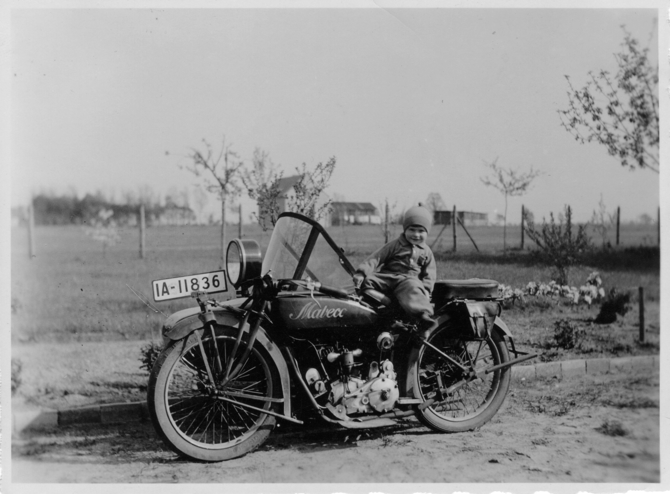 grey scale photo of child sitting on motorcycle