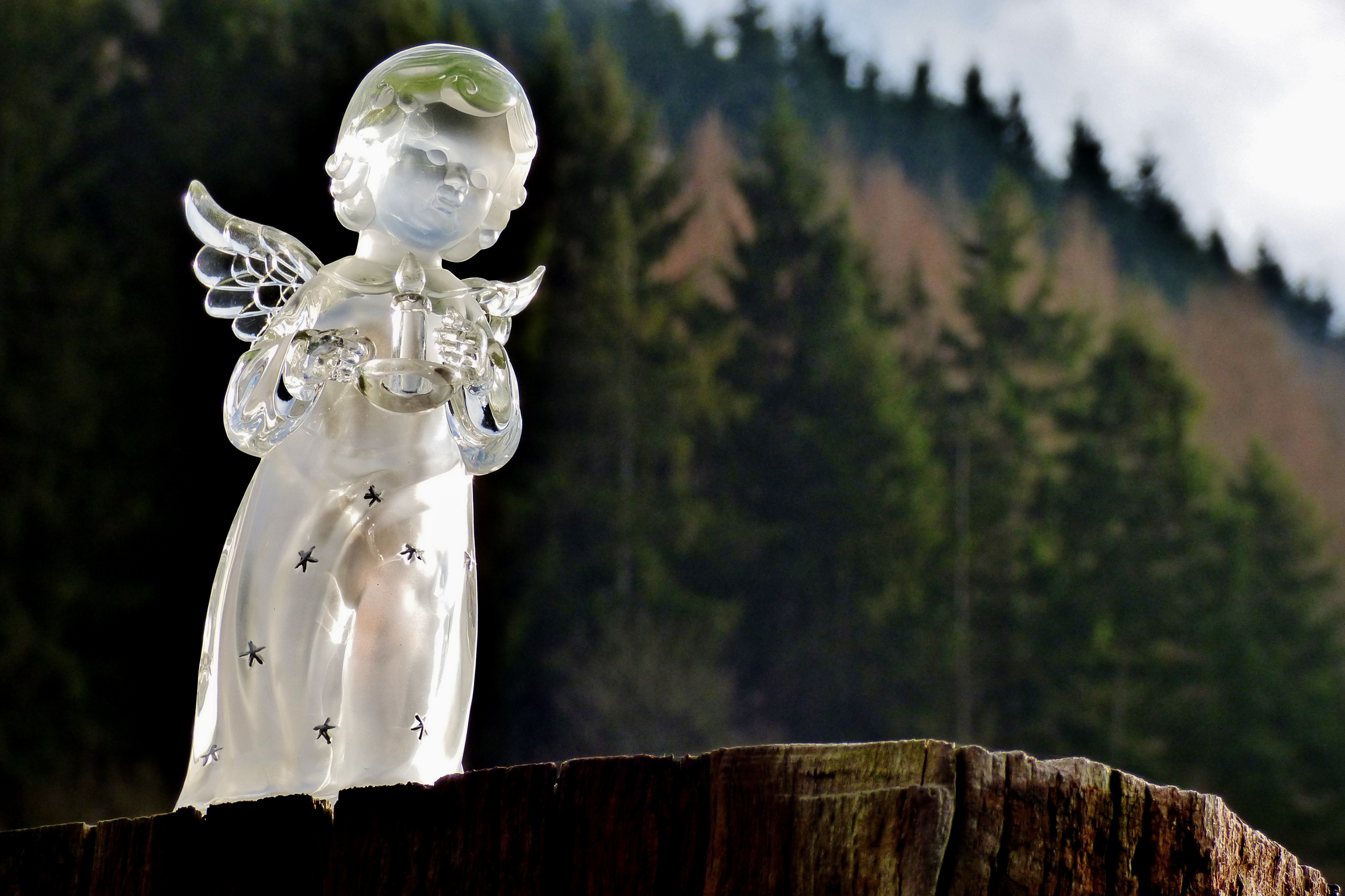 crystal angel holding candle figurine on wood stomp
