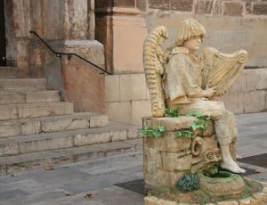 person playing harp sitting on chair figurine thumbnail