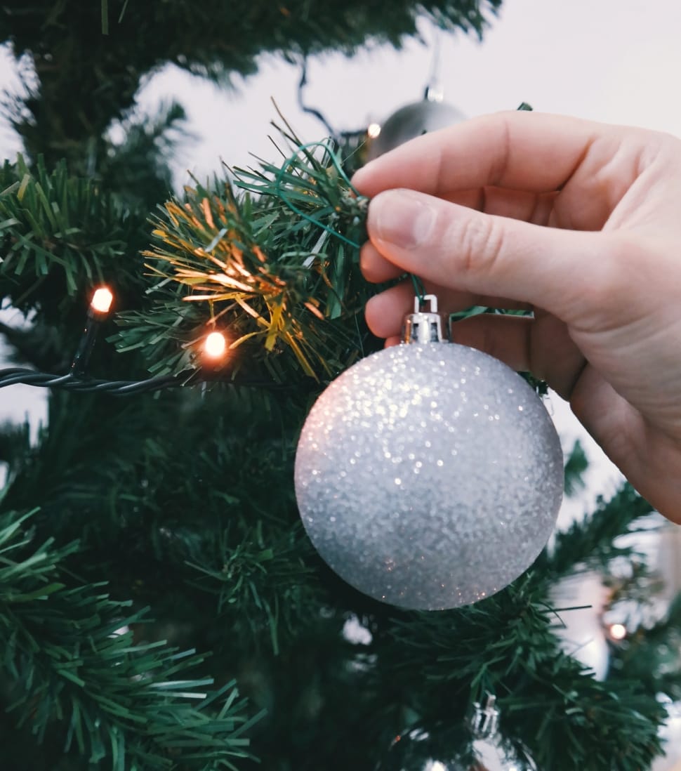 silver christmas ball being hold by human's hand preview