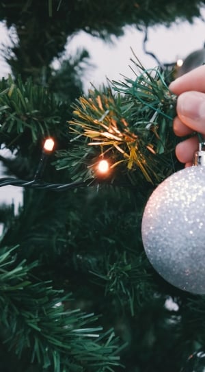 silver christmas ball being hold by human's hand thumbnail