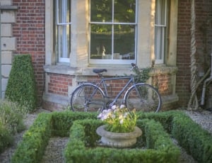 gray commuter bike park on gray surface beside green floral landscape thumbnail