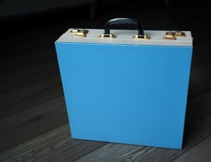 blue suitcase on parquet floor thumbnail
