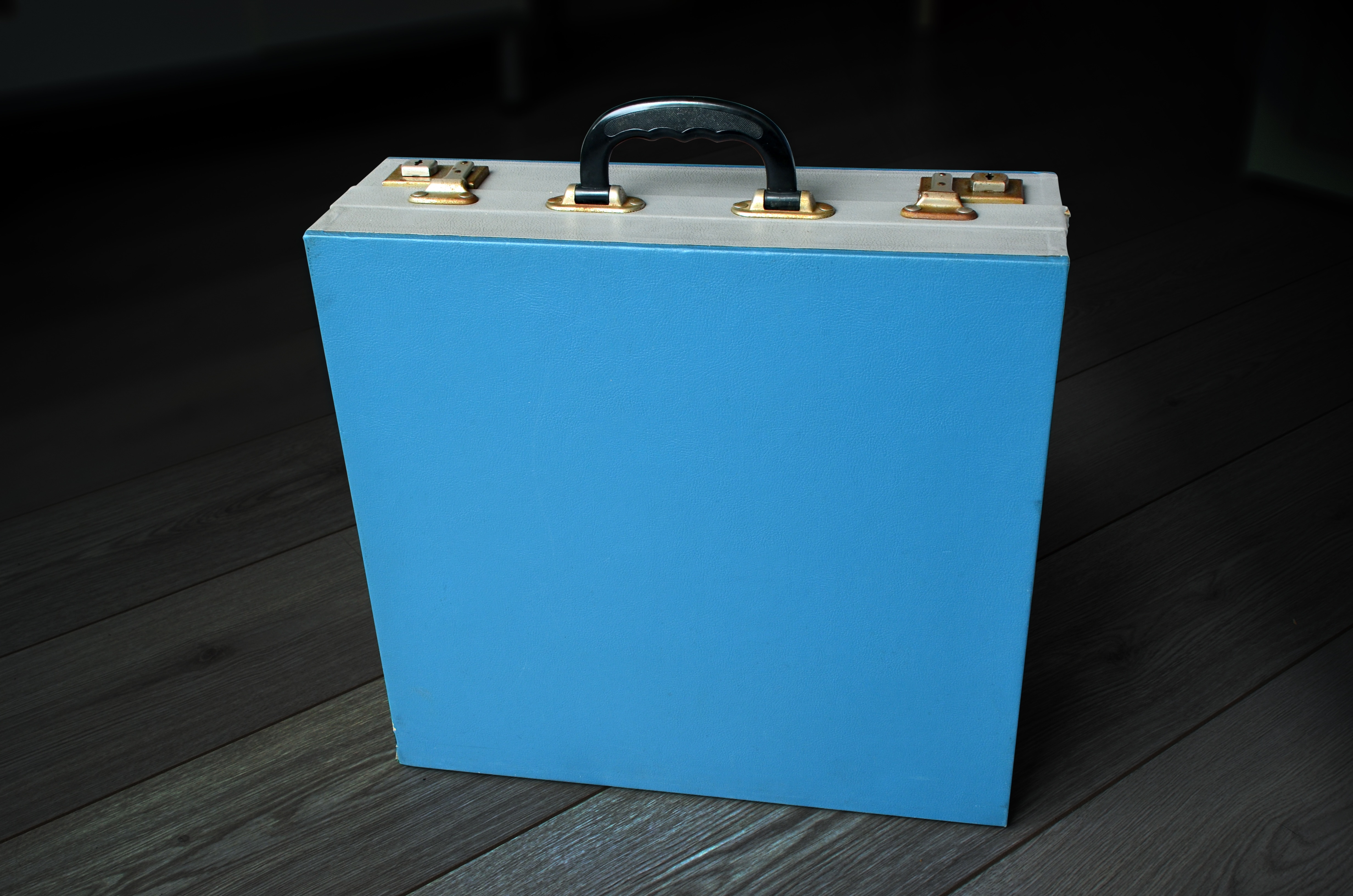 blue suitcase on parquet floor