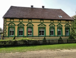 house with yellow and green wall paint and black roof thumbnail