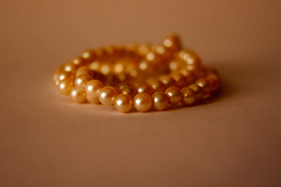 orange pearl necklace on brown concrete surface preview