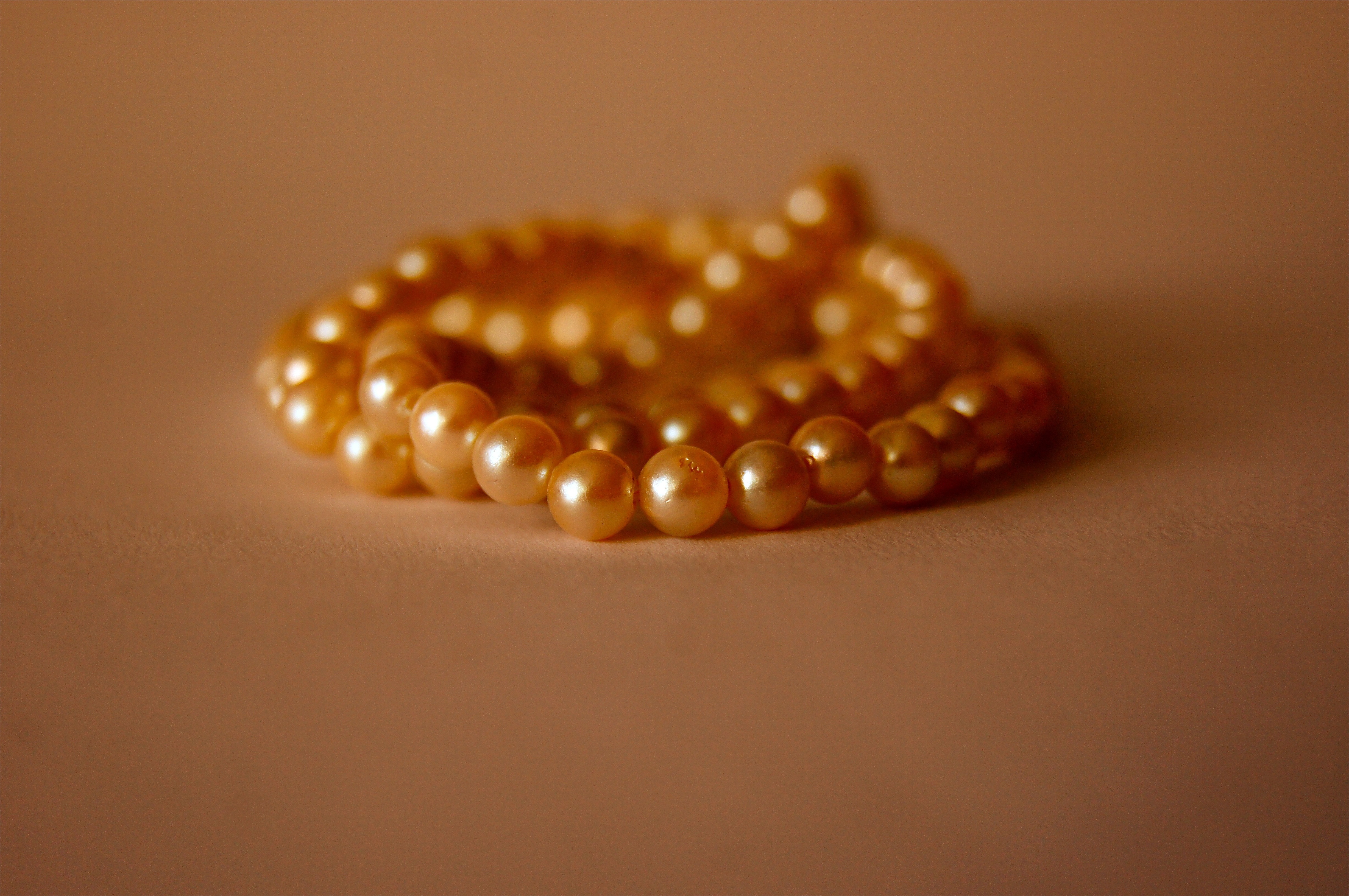 orange pearl necklace on brown concrete surface