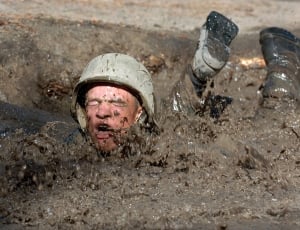 man with helmet dive in the mud during day time thumbnail