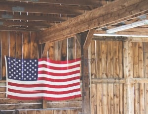flag of u.s.a. hanged on beige wood slatted house thumbnail