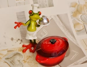 green chef frog figurine beside red casserole thumbnail